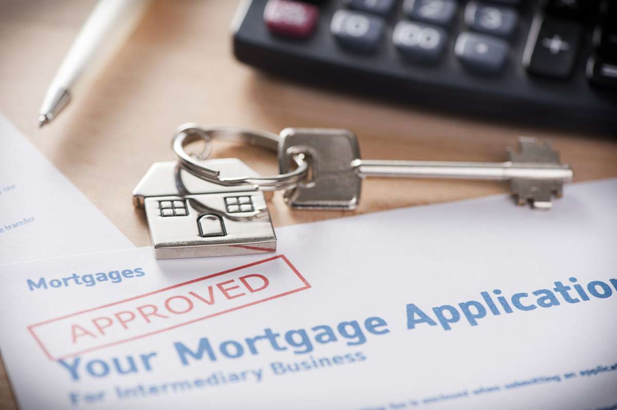 Approved mortgage loan agreement application with house shaped keyring