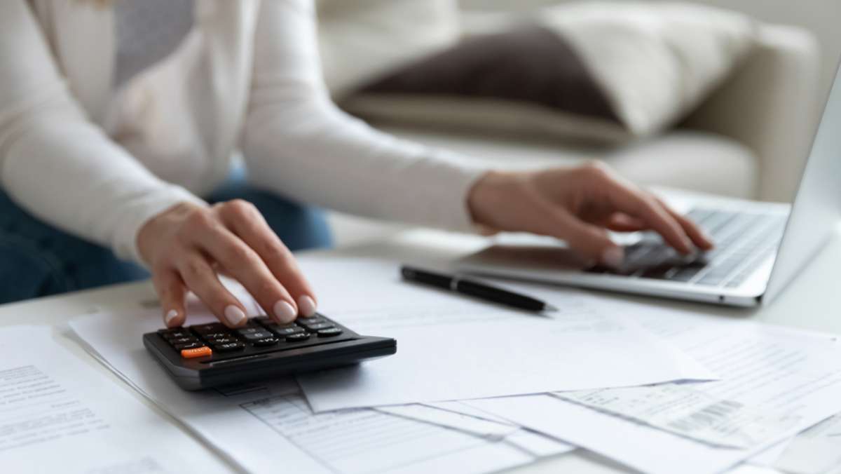 Close up of woman busy paying bills online on computer calculating household finances