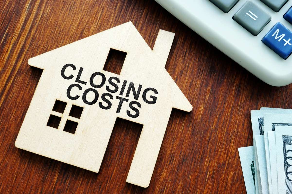 Closing costs. Model of house and money. (R) (S)