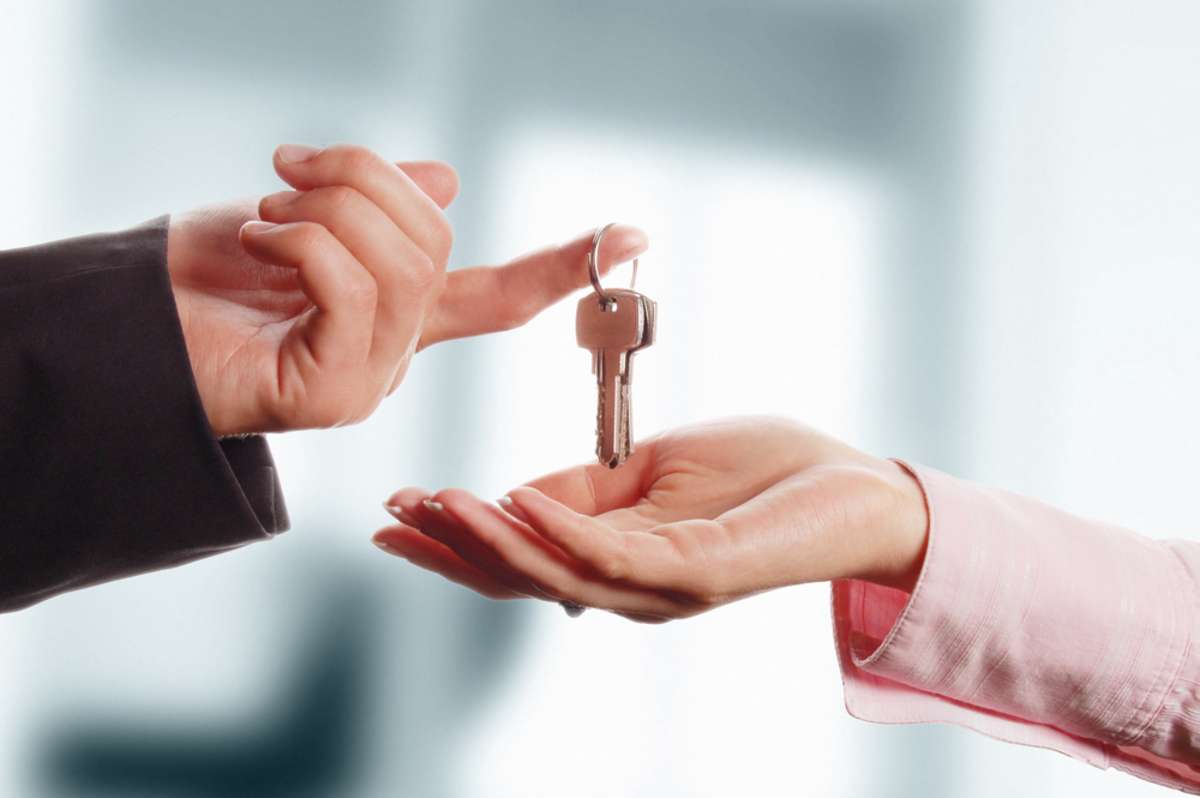 Man handing a women a set of keys