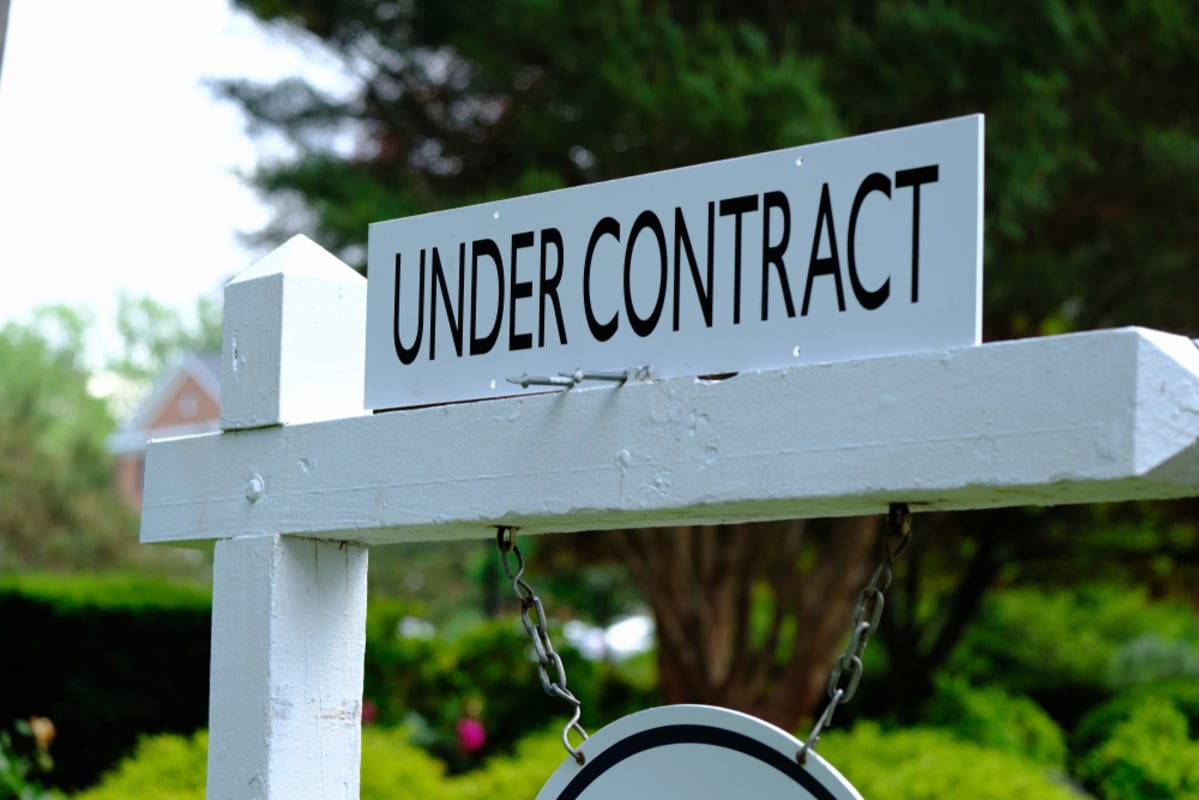 Under contract sign on wooden post (R)