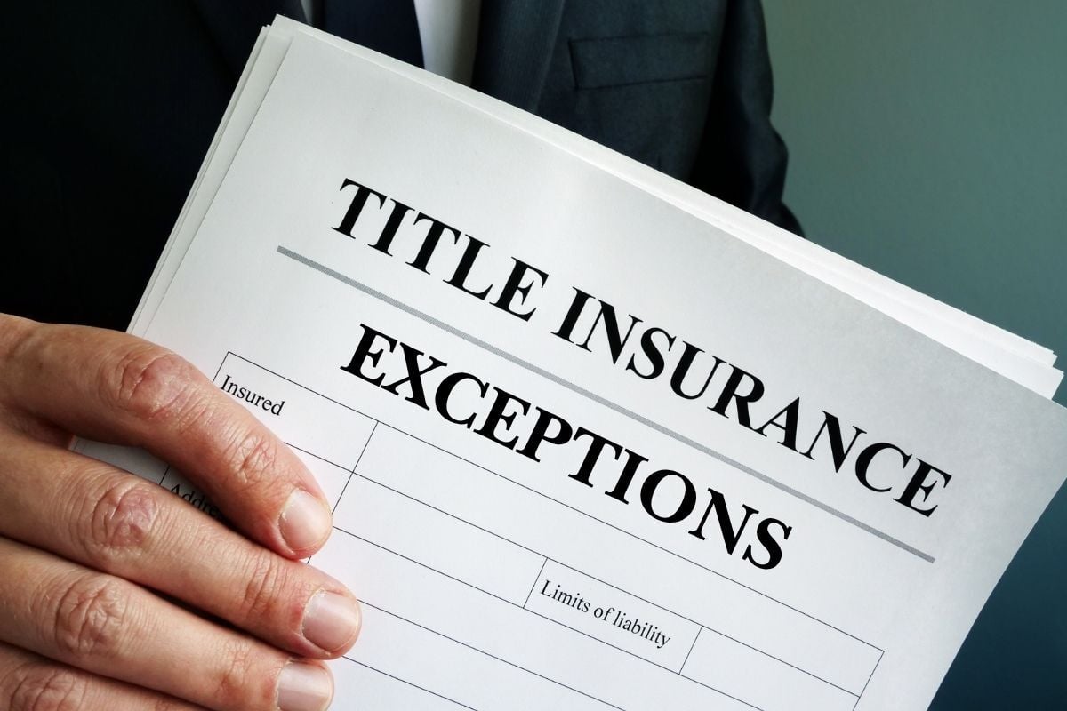 A person holds an insurance form, showing the title insurance standard exceptions in Texas