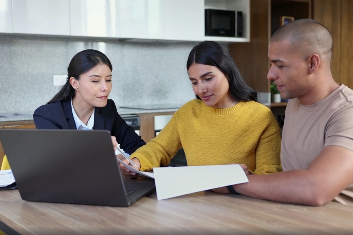 a couple discussing their home purchase with an agent, including how much the down payment is for a house in Texas